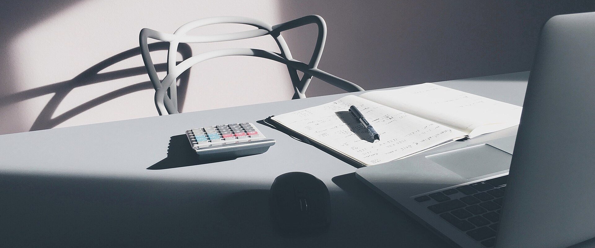 Bureau avec calculatrice, carnet de notes et ordinateur portable pour calculer une indemnité de rupture conventionnelle